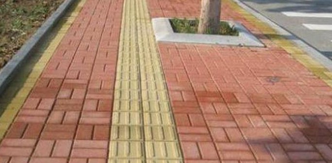 贵州贵阳一盲道为绕开井盖穿过公交站牌，这样设计的盲道有用吗？